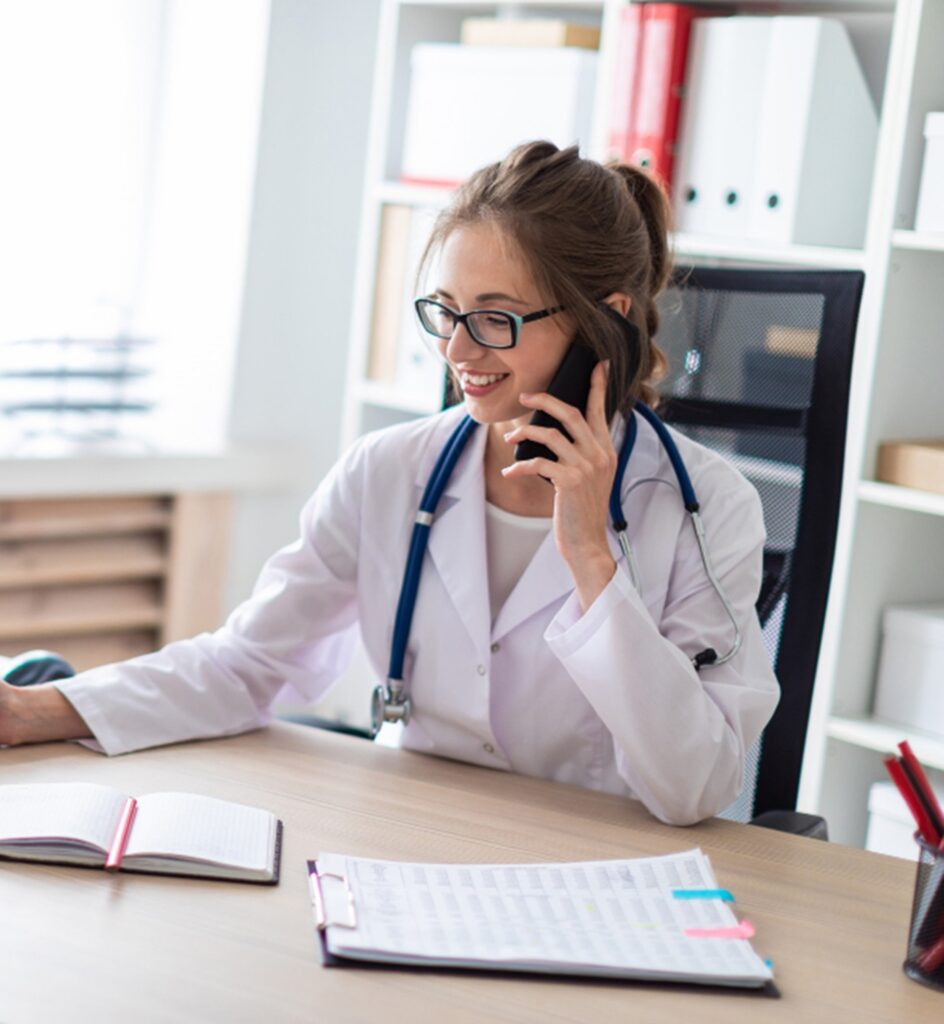 une secrétaire médicale a son bureau au téléphone