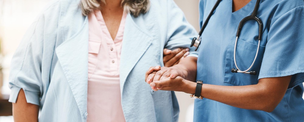 une auxiliaire de vie tenant la main d'une personne agée
